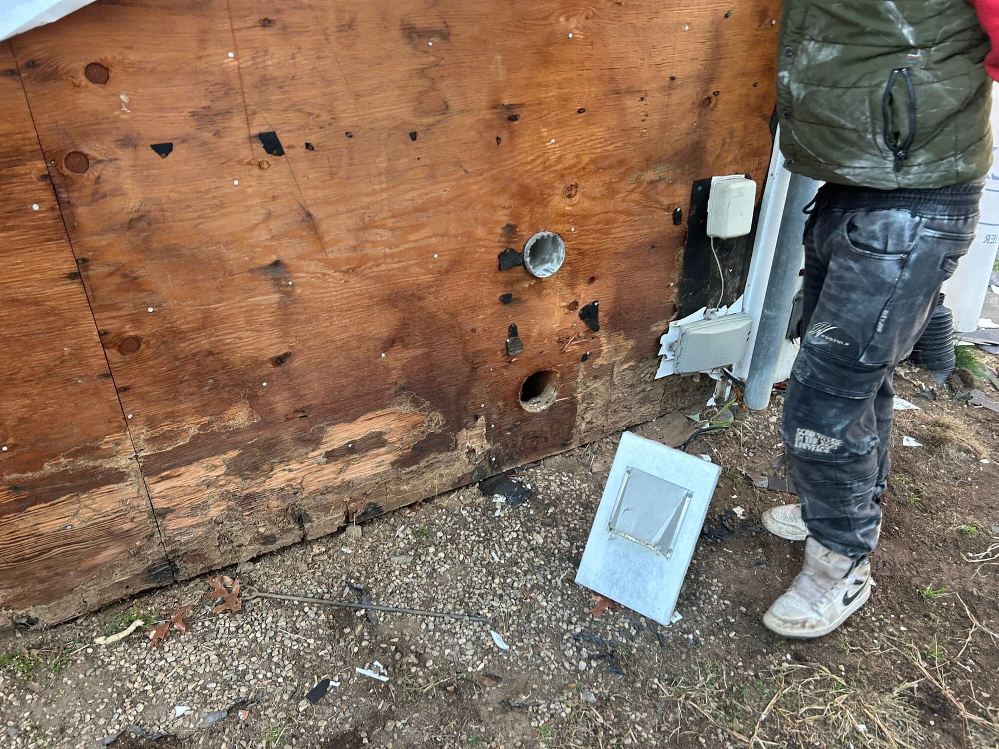 Exposed wall sheathing during a Northern Limits exterior repair, showing the structural details behind the finish